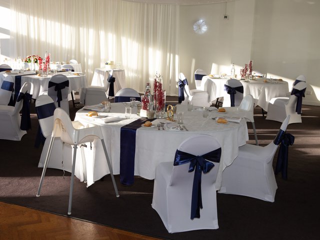 Round tables arranged in blue satin and flowers