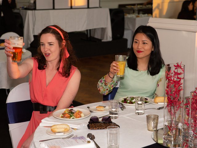 Two guests raise a glass to the married couple